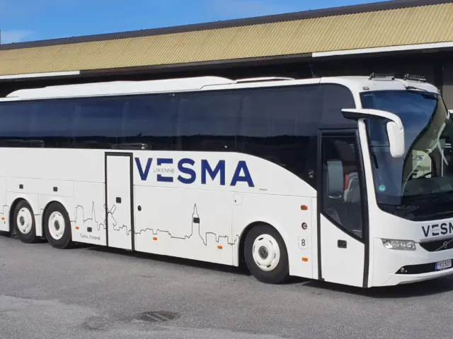Auto nro 10: valkoinen Vesma-tilausajobussi Vesman varikolla